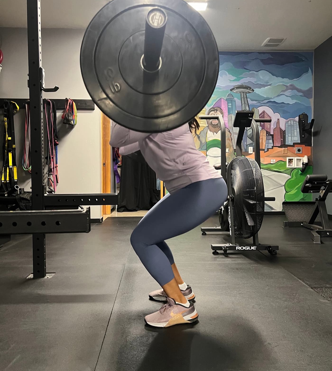 Member performing a back squat under the loaded barbell at Seattle Muscle, Nickerson Street, Seattle
